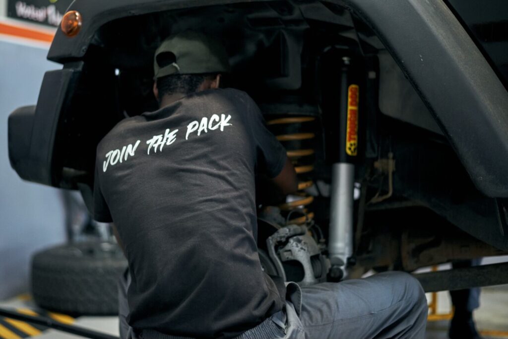 Hi-Range technician fitting a Tough Dog coil spring and shock absorber to a raised vehicle